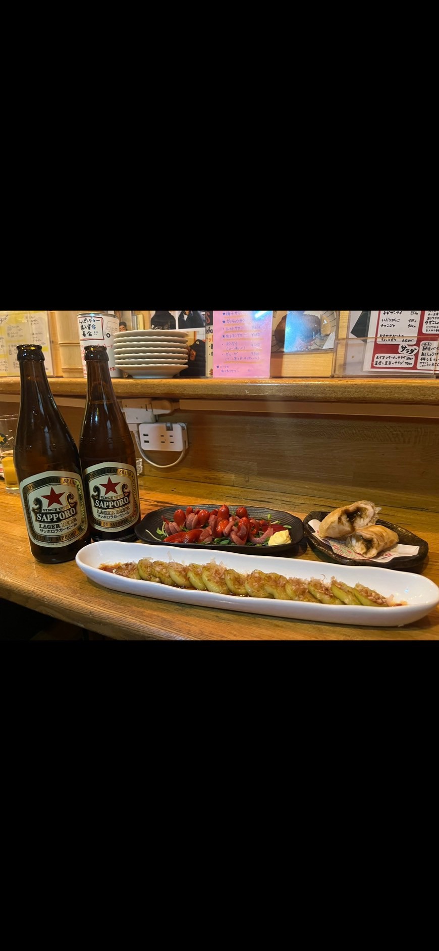 かつお節を添え、白い長皿に盛り付けた焼きナス