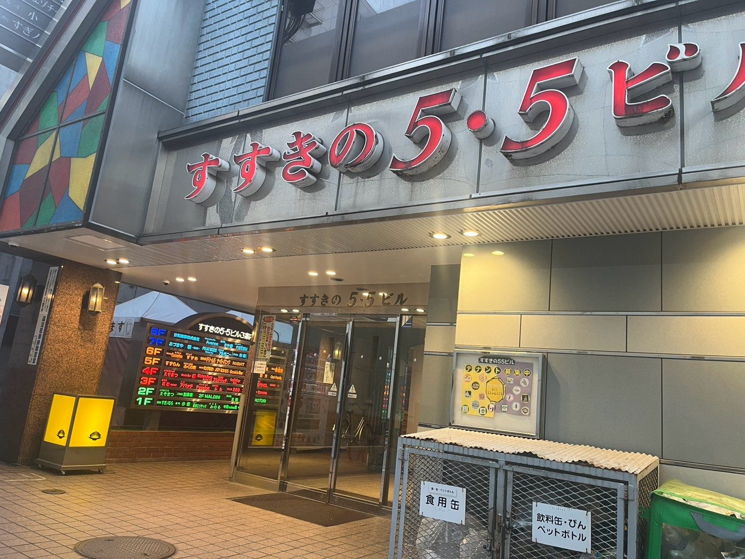 夕暮れのすすきの5・5ビル入口。えぞまつの黄色い看板が灯っている