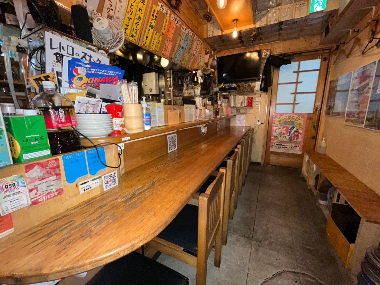 えぞまつの店内。壁いっぱいの品書きと、長く伸びる木のカウンター
